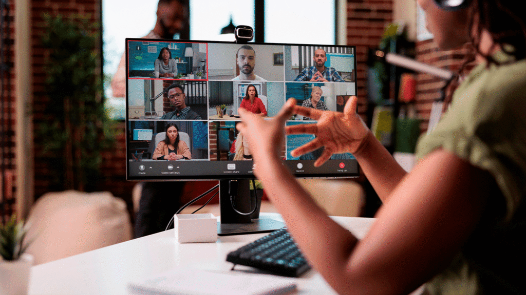 Persona participando en un trabajo remoto desde casa, con varios profesionales conectados en pantalla.