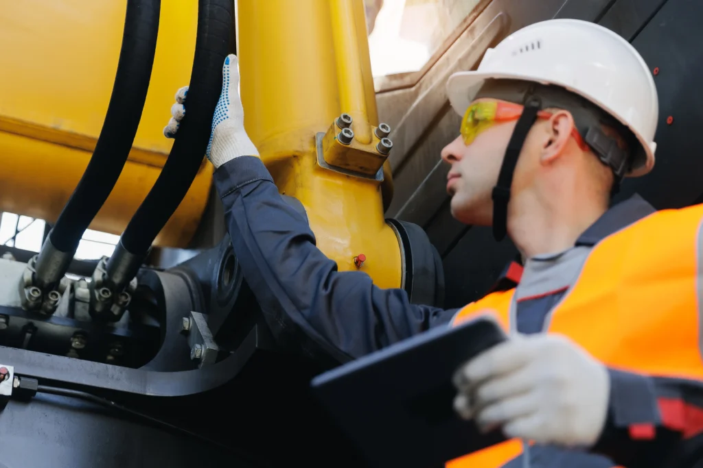 CFS inspector conducting an industrial inspection of mechanical equipment using a digital tablet, wearing a hard hat, safety glasses, and PPE to verify asset integrity.