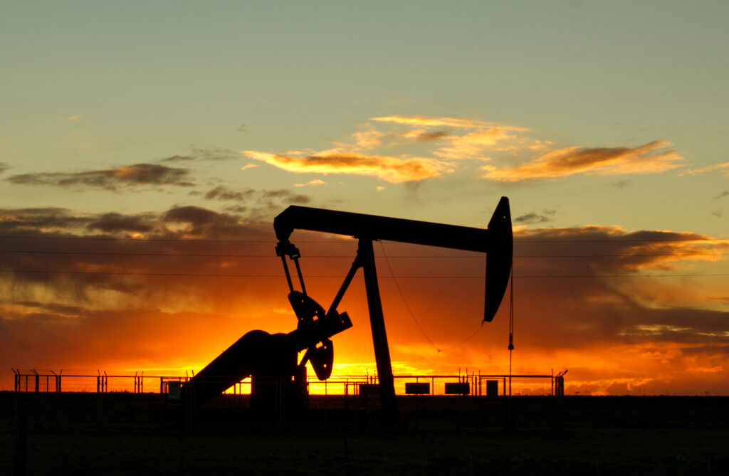 silueta bomba aceite haciendo su trabajo campo petrolero al atardecer cielo multicolor