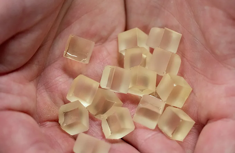 sostienen en las manos cubos de la resina especial para el reciclaje de palas de turbinas eólicas