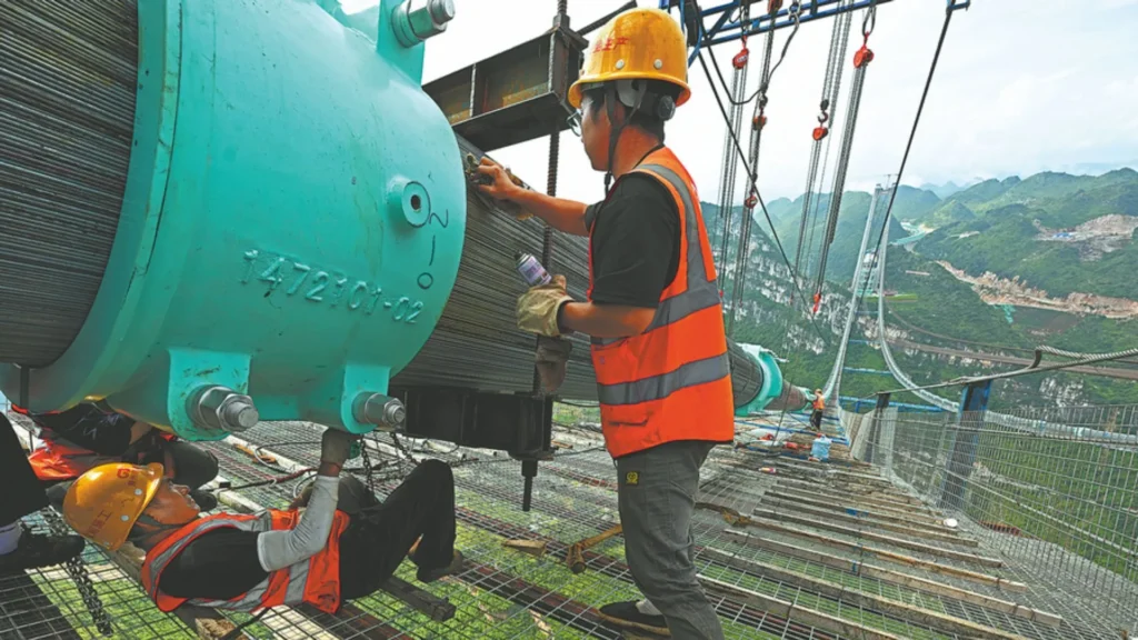 Trabajadores en el puente del Gran Cañón de Huajiang