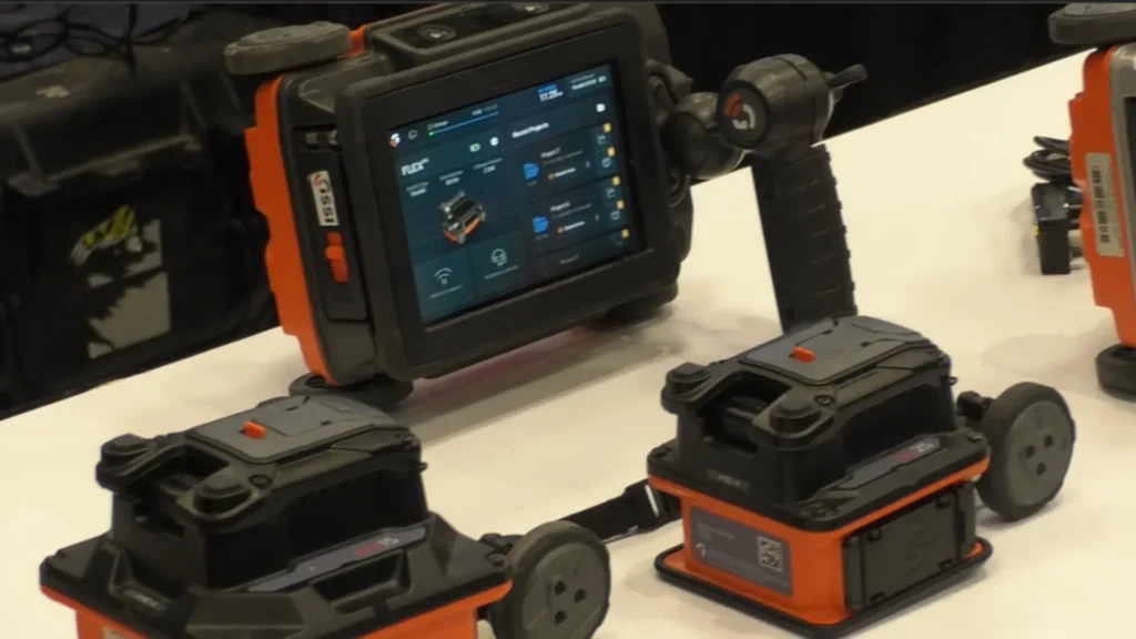 Sistemas GPR FLEX de GSSI para inspección de concreto, con pantalla táctil y módulos de radar portátiles exhibidos en una feria tecnológica.