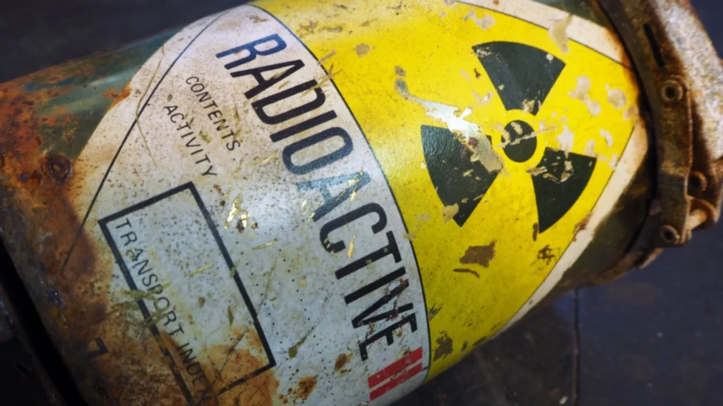Primer plano de un contenedor etiquetado como radiactivo, representando el tipo de residuos tratados en su proceso de reciclar combustible nuclear.