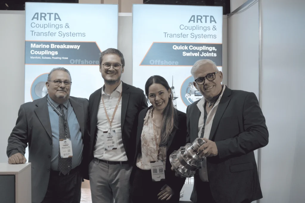 Grupo de representantes de ARTA en el evento SLOM 2025, incluyendo al CEO de Inspenet, posando frente al stand de la compañía.