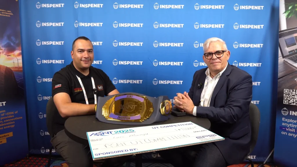 Luis Montoya and Francesco Solari during an interview at ASNT 2025, showing the industrial ultrasound champion belt and prize check.