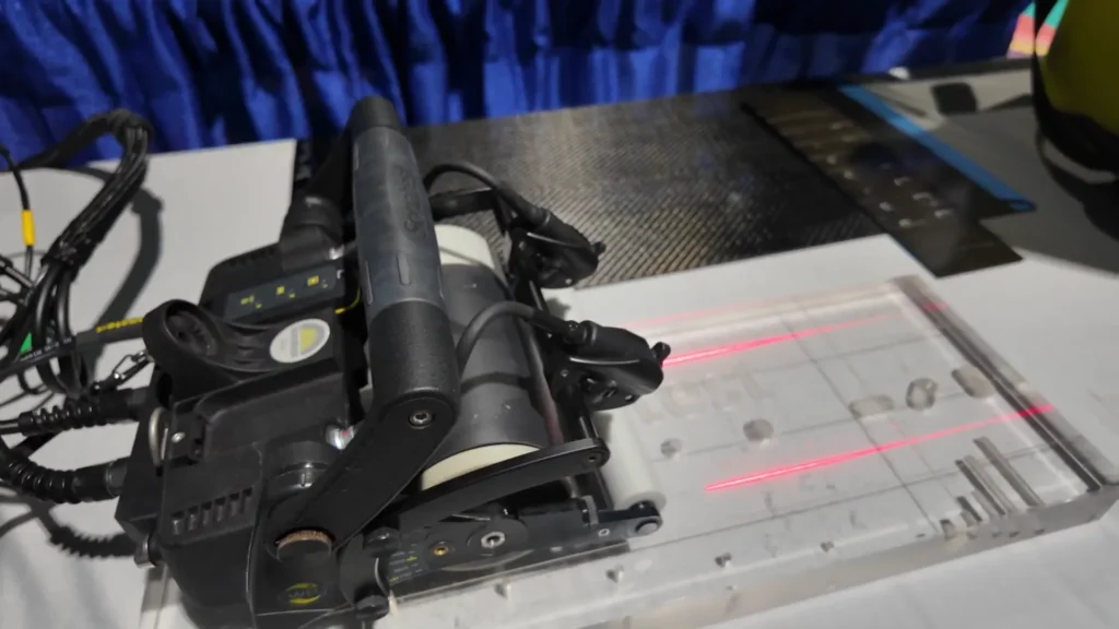 Transductor ultrasónico WheelProbe 2 de Sonatest realizando inspección sobre bloque de prueba con defectos simulados.