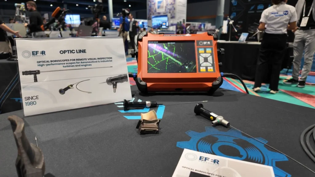 Boroscopio óptico de EFER ENDOSCOPY utilizado para inspección visual remota en motores aeronáuticos, mostrado en el evento ASNT 2025 junto a su monitor de control y componentes.