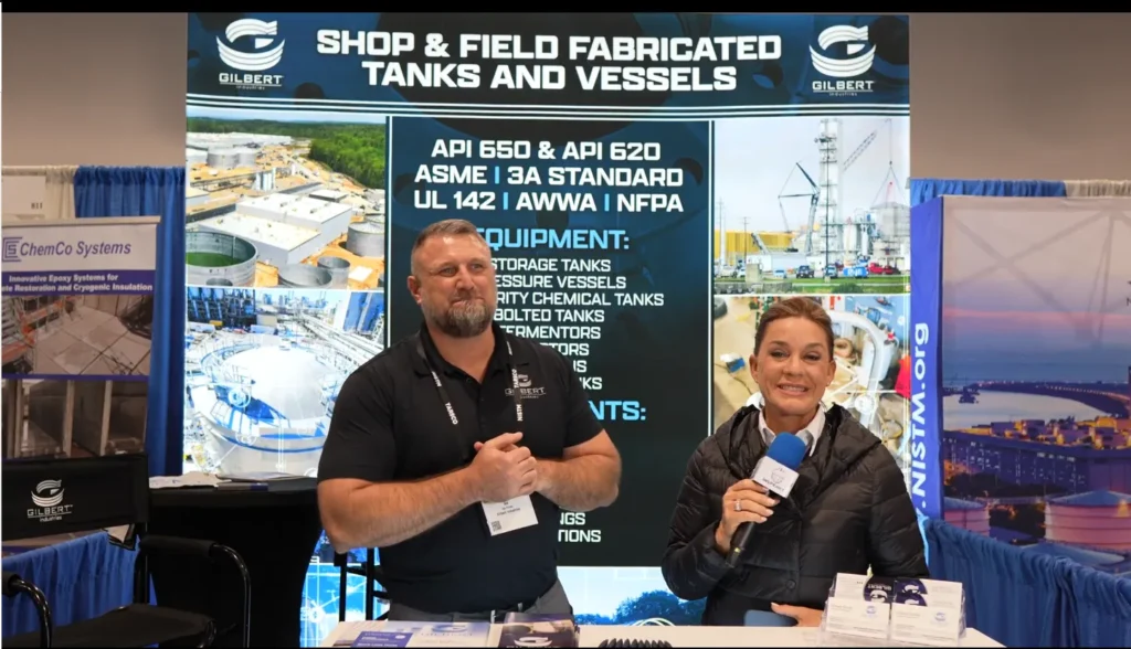 Ike Porter of Gilbert Industries during an interview at NISTM 2025, in front of the industrial tanks and vessels booth.