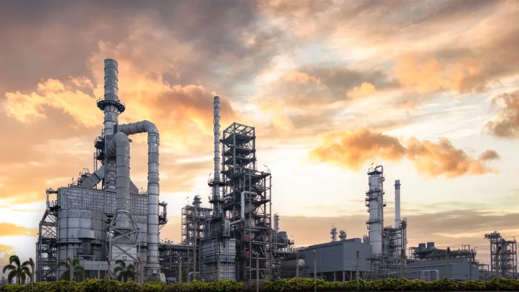 Refiner&iacute;a en Texas con estructuras industriales y torres de procesamiento al atardecer.