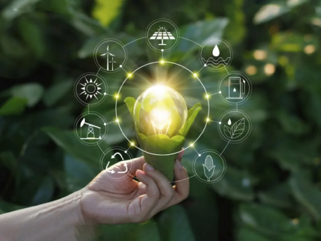 Light bulb held by a hand with clean energy icons representing energy efficiency and sustainability.