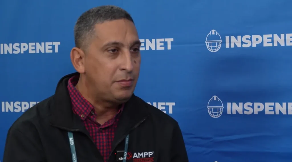 Corrosion training in interview with specialist during an event, in front of a blue background with Inspenet logos.