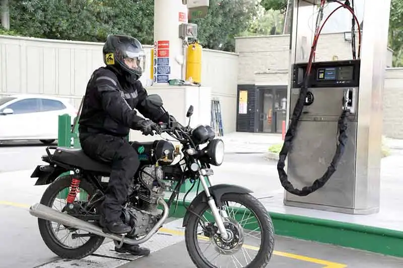 Moto h&iacute;brida cargando gas natural en estaci&oacute;n de servicio con sistema de conversi&oacute;n GNV.
