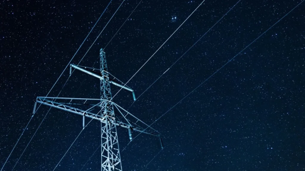 NextEra Energy impulsa una megafusión energética mientras líneas de transmisión eléctrica cruzan un cielo nocturno estrellado.