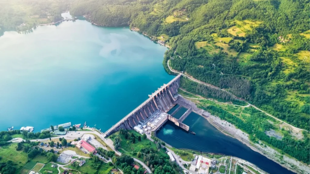 Central hidroeléctrica con presa y embalse rodeados de vegetación.