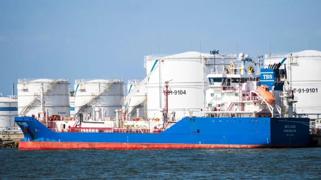 Santos LNG: ship alongside liquefied natural gas storage tanks at a port terminal.